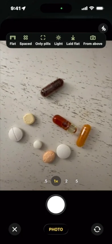 The app camera framing six pills and capsules laid out on a table