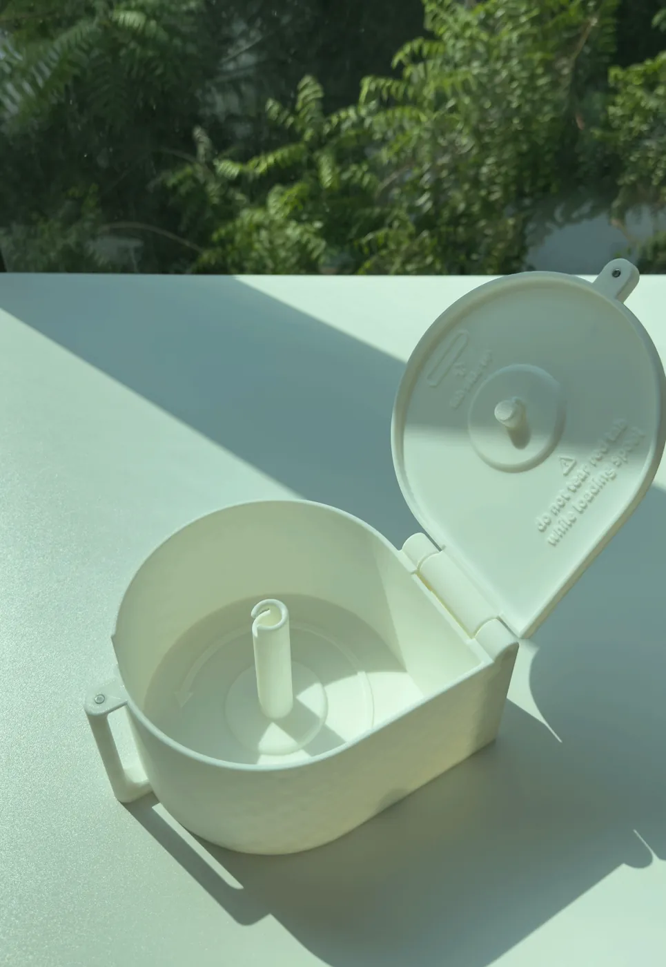 A LioBox with its lid open, showing the empty spindle