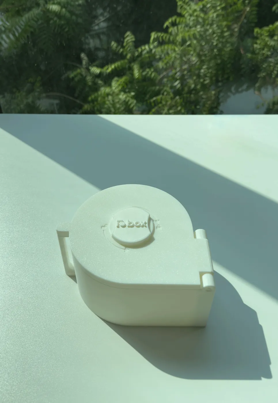 A white LioBox standing on a sunlit table