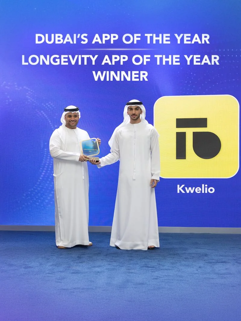 Dubai&rsquo;s App of the Year 2026 trophy presented to Kwelio on stage, under the words Dubai&rsquo;s App of the Year, Longevity App of the Year, Winner, beside the Kwelio logo